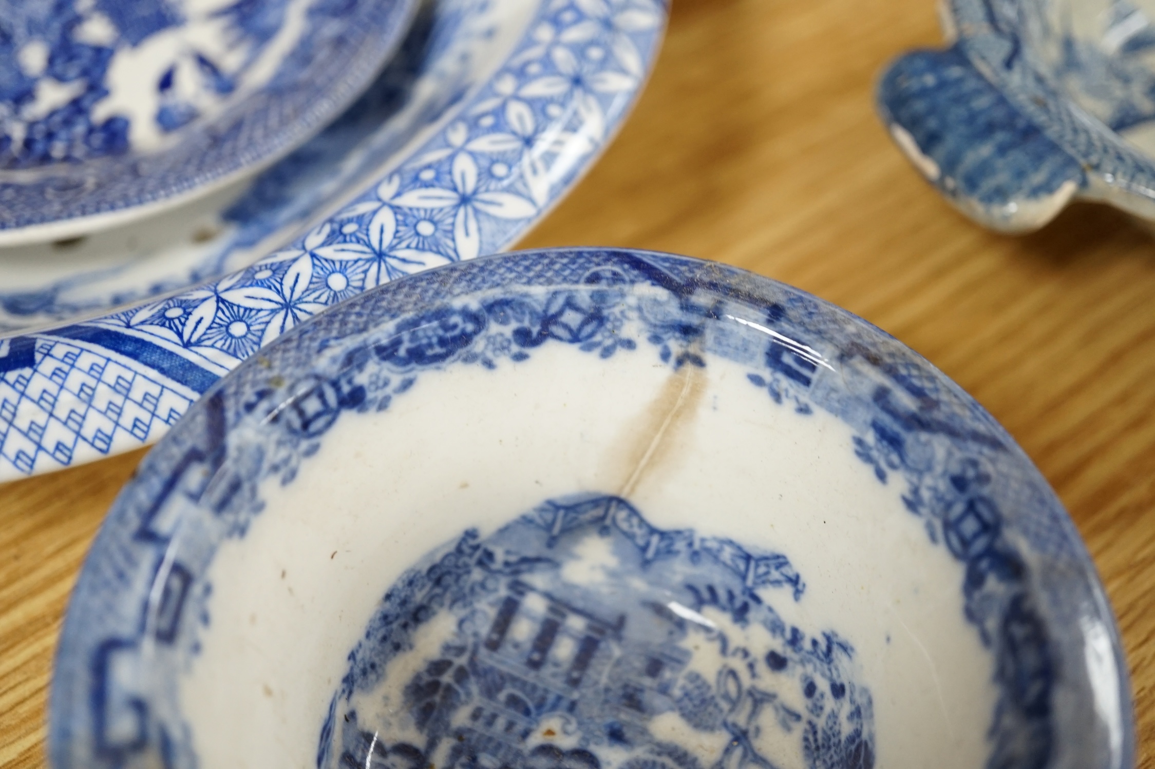 A mixed collection of Willow pattern blue and white dinnerware, including four tureens and covers, plates meat dishes etc. (large quantity). Condition - varied poor to fair to good